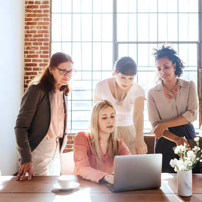 Group of women talking and looking at computer